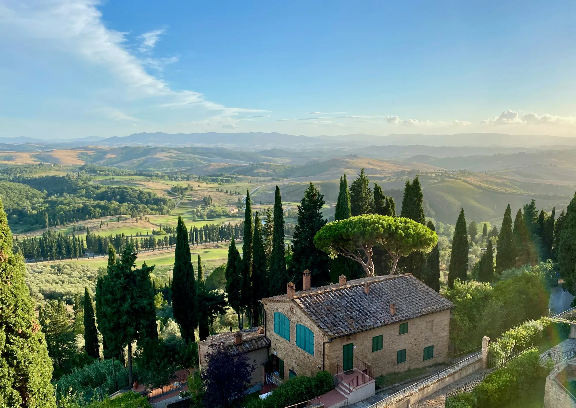 Stenen boerderij tussen cipressen boven een Toscaans dal bij Castelfalfi